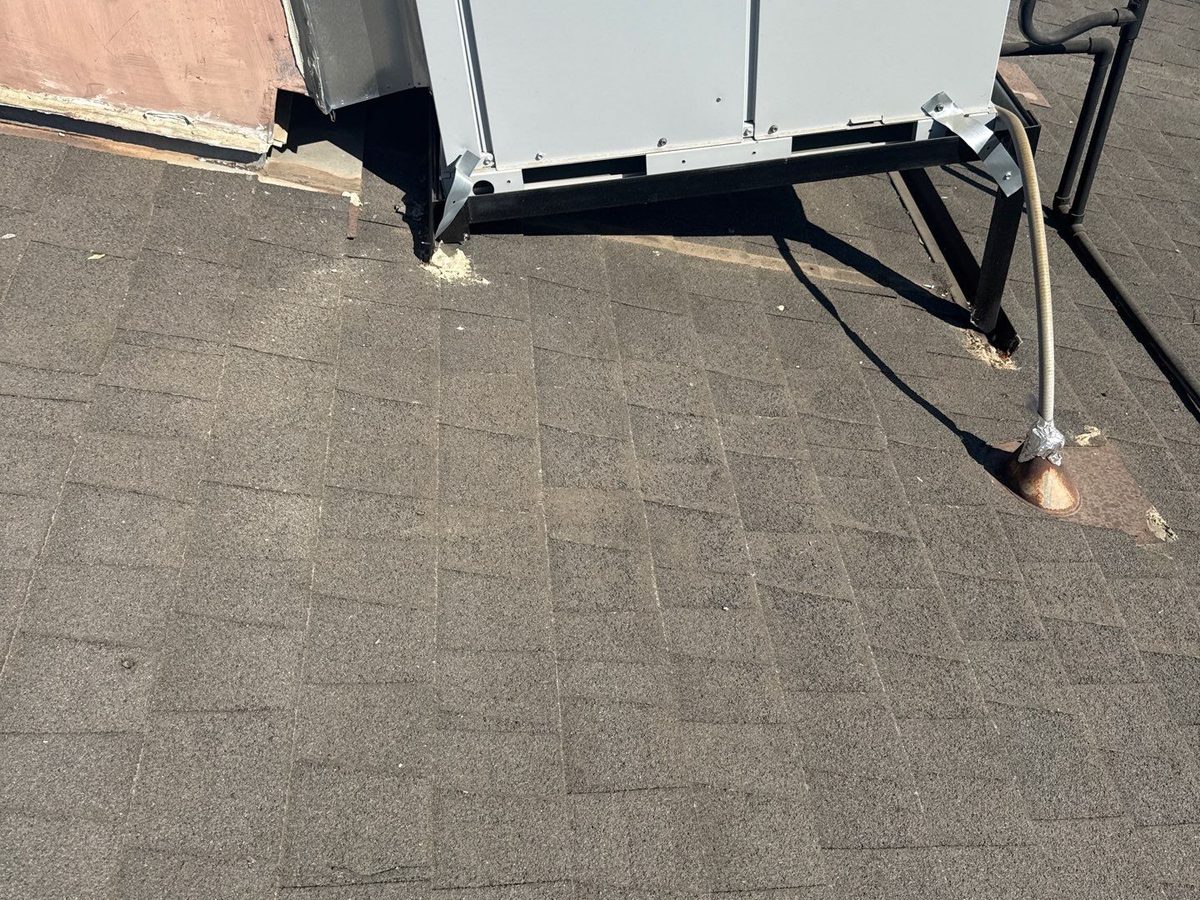 A Bosch rooftop heat pump on a Fresno shingle roof, with worn, granule-bare shingles around the unit's base
